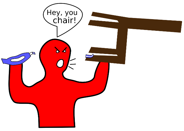 A person holds a chair in one hand with the chair legs facing him and container of toothpaste in the other.  Some toothpaste is on one of the chair legs. He looks mad and is shouting at the chair.